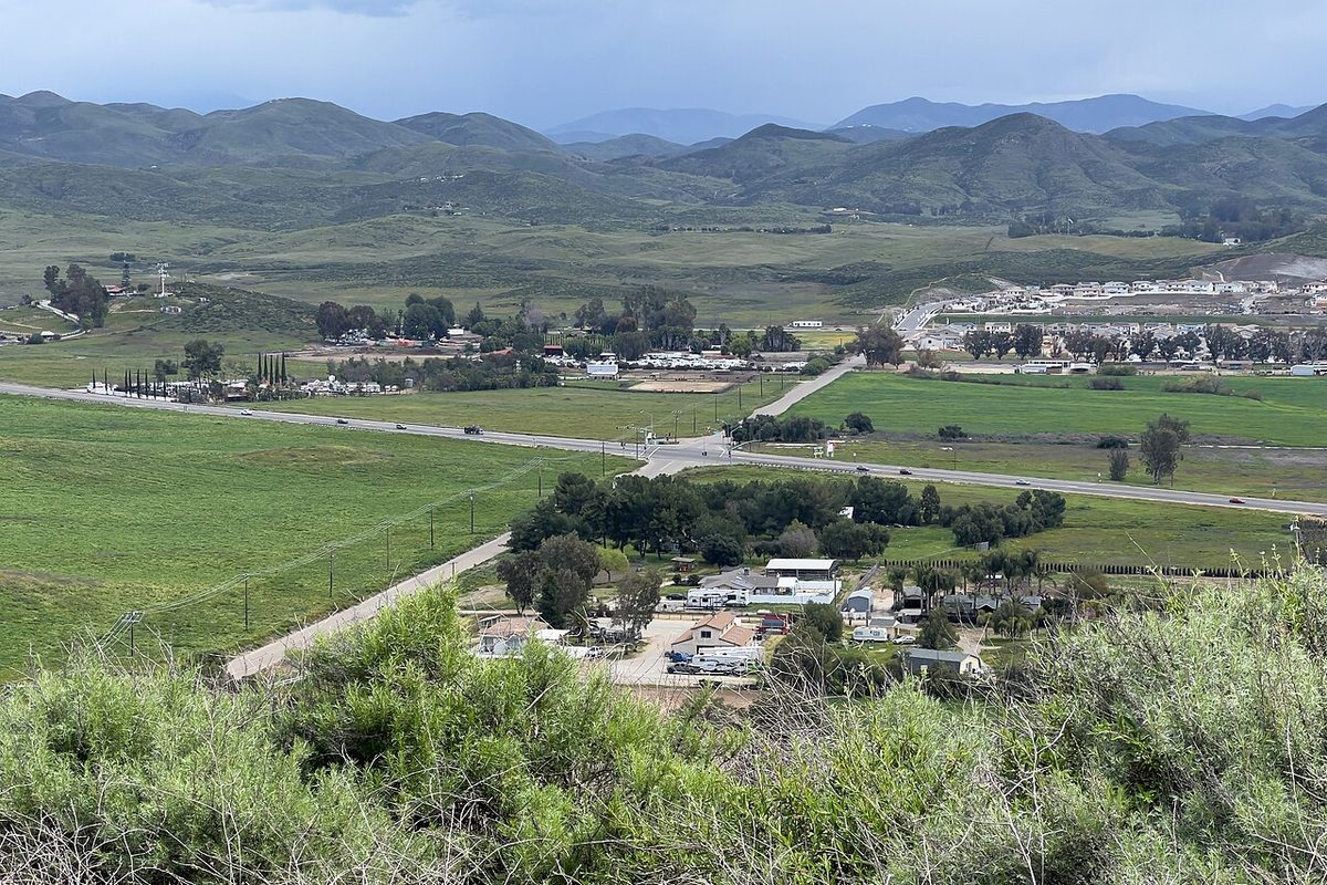 View over farmland and Winchester Road in Winchester, California, toward the hills